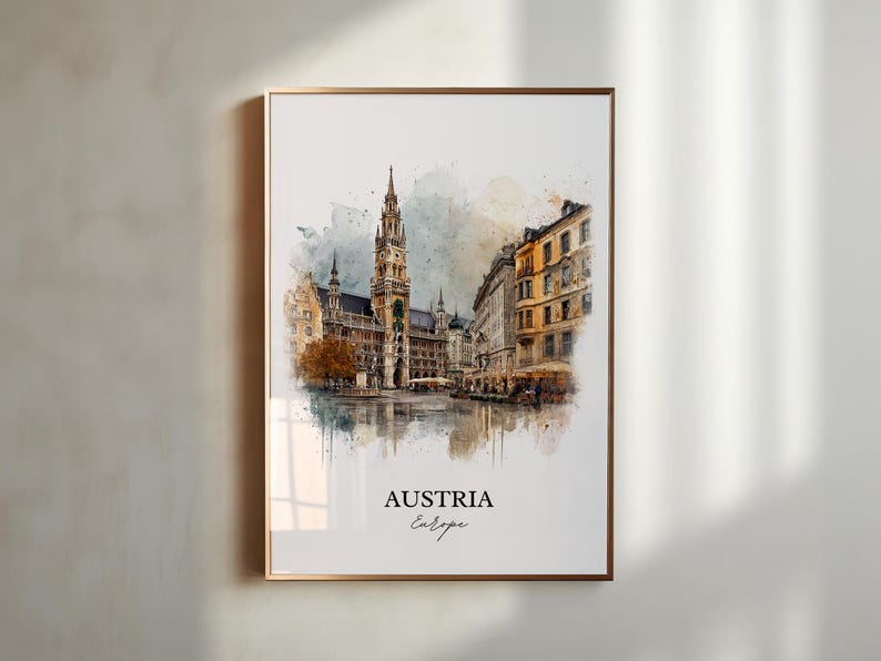 May include: A framed watercolour print depicting a European city, with a gold-coloured frame. The image shows a detailed view of a historic building with a tall tower, other buildings, and a street scene. The text "AUSTRIA Europe" is at the bottom.