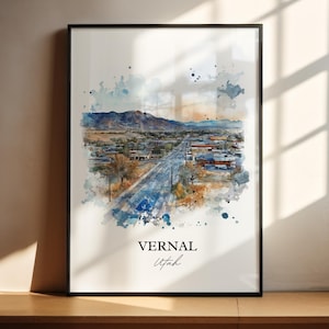 May include: A watercolor painting of Vernal, Utah. The painting depicts a street lined with buildings and trees, with a mountain in the background. The painting is framed in a black frame.