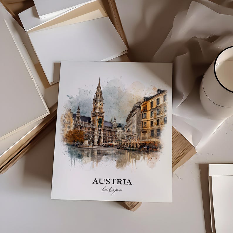 May include: A square print with a watercolour illustration of a European city, including a tall clock tower. The print has the words "AUSTRIA Europe" at the bottom. The print is on a white surface.