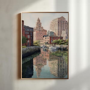 May include: Watercolor painting of a city waterfront scene. Buildings in shades of red and beige line the water's edge, with reflections in the water. Several white boats are docked. The artwork is framed in a gold-colored frame.
