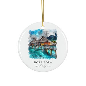 Könnte beinhalten: Ein rundes, weißes Keramikornament mit einer Aquarellillustration von Überwasser-Bungalows in Bora Bora, Französisch-Polynesien. Das Design zeigt einen Holzsteg, türkisfarbenes Wasser und Berge. Der Text lautet BORA BORA French Polynesia.