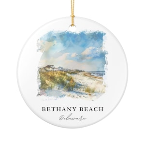 May include: A round ceramic ornament featuring a watercolor painting of Bethany Beach, Delaware. The image depicts a beach scene with sand dunes, houses, and a blue sky with clouds. The text "BETHANY BEACH Delaware" is printed below the image. A gold string is attached for hanging.