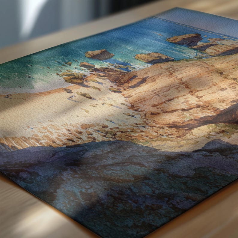 May include: A rectangular decorative mat featuring a coastal scene. The image depicts a sandy beach, rocky cliffs, and turquoise water under a blue sky. The mat is likely made of a durable material.
