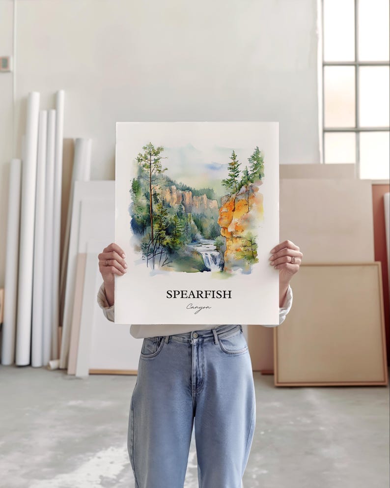 May include: A watercolor painting of Spearfish Canyon, a scenic canyon in South Dakota. The painting depicts a waterfall cascading down a rocky cliffside, surrounded by lush green trees. The text "Spearfish Canyon" is printed below the image.