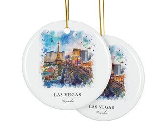 May include: Two round white ceramic ornaments hanging from gold strings. Each features a colorful watercolor illustration of the Las Vegas skyline, including the Eiffel Tower replica. The text LAS VEGAS Nevada is printed in black below the image.