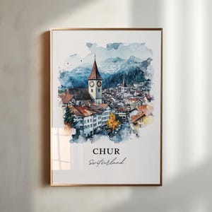 Puede incluir: Impresión en acuarela de Chur, Suiza, con una iglesia y una torre del reloj, rodeada de edificios y montañas. La obra de arte tiene un estilo suave y pictórico con tonos azules, marrones y naranjas. El texto "CHUR Switzerland" está en la parte inferior.