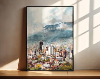 May include: Watercolor painting of a cityscape with a mountain in the background. The artwork features a variety of buildings in shades of white, yellow, orange, and red. The sky is a mix of blue and white, and the painting is framed in a black border.