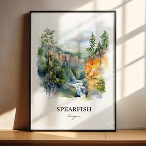 May include: Watercolor painting of Spearfish Canyon, a scenic canyon in South Dakota, featuring a waterfall, lush green trees, and rocky cliffs. The painting is framed in black and has the words "Spearfish Canyon" written below the image.