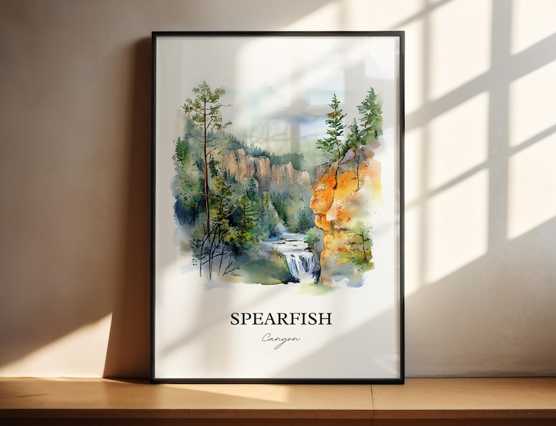 May include: Watercolor painting of Spearfish Canyon, a scenic canyon in South Dakota, featuring a waterfall, lush green trees, and rocky cliffs. The painting is framed in black and has the words "Spearfish Canyon" written below the image.