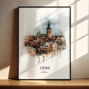 May include: Framed watercolor print of Cēsis, Latvia, featuring a detailed depiction of the town's architecture. The artwork showcases a church tower and buildings in shades of brown, red, and white, with a black frame. The word "Cēsis" is written at the bottom.