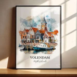 Könnte beinhalten: Ein Aquarellbild eines holländischen Dorfes mit einem Kirchturm und bunten Häusern entlang eines Kanals. Ein Boot liegt im Wasser. Der Text "Volendam, Niederlande" ist unter dem Bild gedruckt.