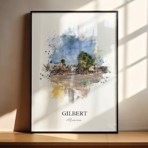 May include: A framed watercolor print featuring a street scene in Gilbert, Arizona. The artwork showcases a vibrant splash of blue and green hues, with the town's name and state written below.