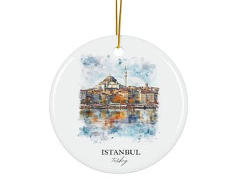 Op de afbeelding: Een rond wit keramieken ornament met een aquarelillustratie van de skyline van Istanbul, inclusief een moskee en minaret met reflectie in het water. De tekst ISTANBUL Turkey staat in het zwart onder de afbeelding, met een gouden koord.