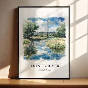 May include: A framed watercolour print of the Trinity River in California. The artwork shows a tranquil river scene with verdant trees, grassy banks, and a cloudy blue sky. The text "TRINITY RIVER California" is printed at the bottom.