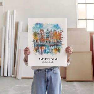 Puede incluir: Una pintura de acuarela de &Aacute;msterdam, Pa&iacute;ses Bajos, con edificios coloridos y un canal. La pintura tiene una gama de colores azul, verde y naranja. El texto "AMSTERDAM Pa&iacute;ses Bajos" est&aacute; escrito en negro en la parte inferior de la pintura.