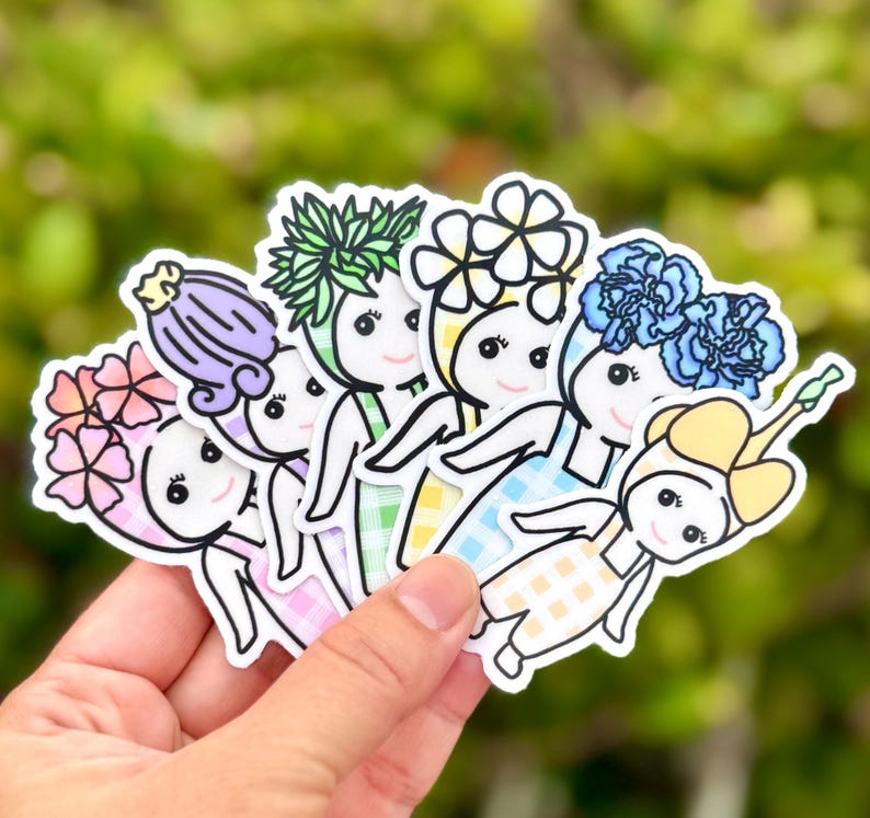 Puede incluir: Una colecci&oacute;n de pegatinas coloridas con personajes de dibujos animados con tocados florales. Cada pegatina tiene un dise&ntilde;o floral &uacute;nico en tonos rosa, morado, verde, amarillo y azul. Los personajes sonr&iacute;en y visten vestidos.