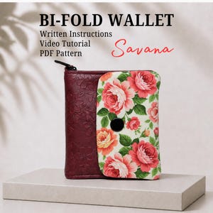 May include: A bi-fold wallet featuring a dark maroon embossed floral section and a cream-colored flap with a vibrant pink and orange rose print. The wallet includes a black circular snap closure and text reading BI-FOLD WALLET, Written Instructions, Video Tutorial, PDF Pattern, and Savana.