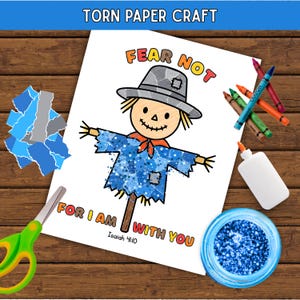 May include: A torn paper craft activity sheet featuring a scarecrow illustration with the text FEAR NOT FOR I AM WITH YOU Isaiah 41:10. The scarecrow wears a gray hat and blue shirt. Includes scissors, crayons, glue, and blue glitter.