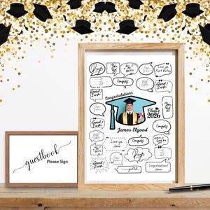 Può includere: Una stampa incorniciata a tema laurea con una foto di un laureato con cappello e toga, circondata da fumetti con messaggi di congratulazioni. Un cartello più piccolo incorniciato recita "libro degli ospiti, per favore firma". Coriandoli dorati e cappelli di laurea decorano lo sfondo.