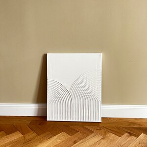 May include: White abstract painting with a textured, raised design of curved lines on a canvas.