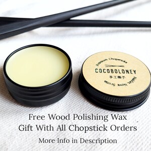 May include: A small tin of wood polishing wax with a black lid. The label on the tin reads "Premium Chopsticks COCOBOLONEY 手工模子 Handmade"