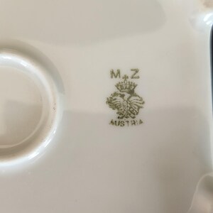 May include: Close-up of a white ceramic plate with a green mark that reads "M+Z" and "AUSTRIA".