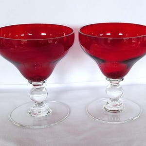 Pode incluir: Dois copos de margarita de vidro vermelho com hastes e bases de vidro transparente.