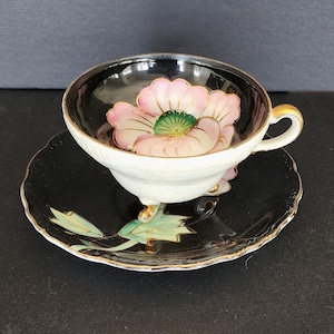 Vintage porcelain hand painted black footed teacup and saucer with pink flower
