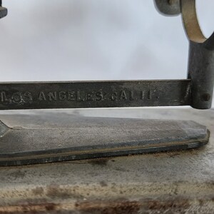 Peut inclure: Une balance en m&eacute;tal vintage avec une finition argent&eacute;e. La balance a une base en m&eacute;tal et un bras en m&eacute;tal avec l'inscription "Los Angeles, Calif."