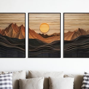 May include: A set of three wood wall art prints featuring a layered, abstract landscape with mountains and waves. The middle print has a large, yellow sun in the sky.