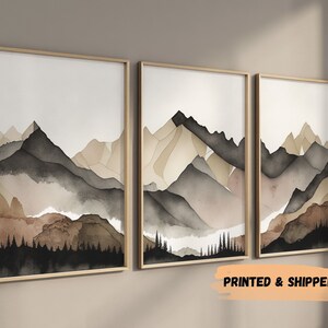 Peut inclure: Ensemble de trois impressions aquarelle encadr&eacute;es repr&eacute;sentant un paysage de montagne dans des tons de brun, beige et gris. Les impressions sont dispos&eacute;es en rang&eacute;e et pr&eacute;sentent une esth&eacute;tique simple et moderne.