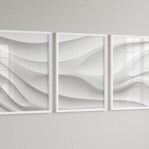 Puede incluir: Tres impresiones enmarcadas en blanco con patrones ondulados abstractos en tonos de blanco y gris.