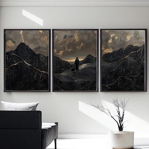May include: Three black framed prints of a dark, stormy landscape with a lone figure walking a dog on a mountain path. The prints have a distressed, textured look with gold accents.