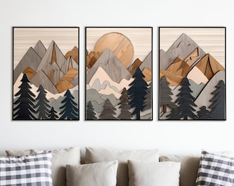May include: Three framed wood art prints depicting a stylized mountain landscape with a sun and trees. The mountains are layered in shades of brown, gray, and white. The trees are dark green and black. The sun is a circle of light wood.