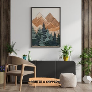 May include: A framed print of a layered wood art piece depicting a mountain range with trees in the foreground. The mountains are in shades of brown and orange, while the trees are in shades of green and blue.
