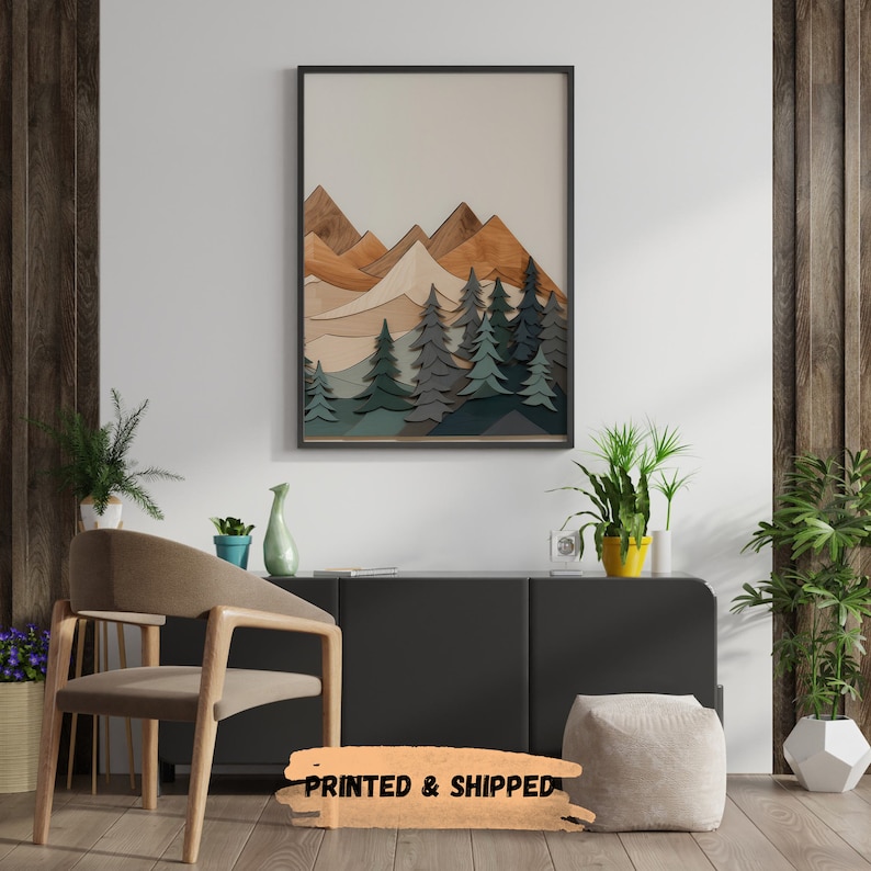 May include: A framed print of a stylized mountain landscape with a layered wood effect. The mountains are in shades of brown and beige, with a forest of green trees in the foreground.