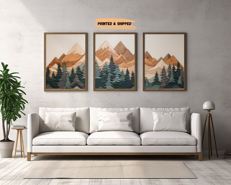 May include: Three framed wood art prints with a layered mountain and forest scene. The mountains are in shades of brown and the trees are in shades of green and blue.
