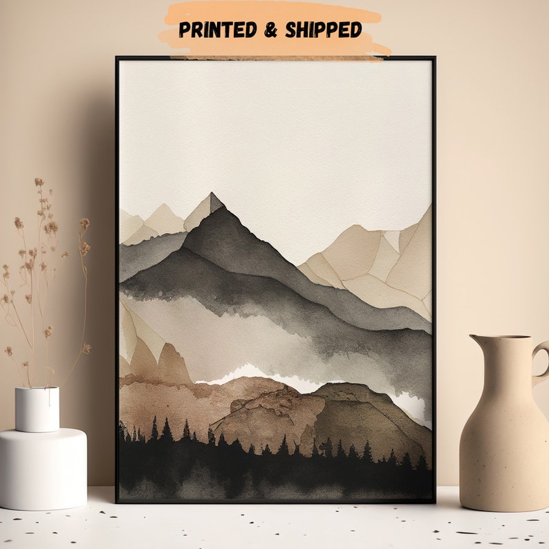 Peut inclure: Une peinture &agrave; l'aquarelle d'une cha&icirc;ne de montagnes avec une for&ecirc;t au premier plan. Les montagnes sont peintes dans des tons de brun, de gris et de blanc, et la for&ecirc;t est peinte en noir. La peinture a un style minimaliste et serait magnifique dans une maison moderne.