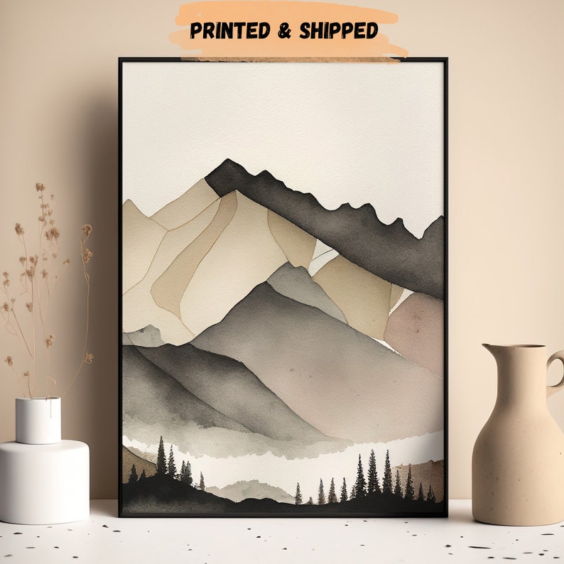 Peut inclure: Peinture &agrave; l'aquarelle d'une cha&icirc;ne de montagnes avec une vall&eacute;e brumeuse au premier plan. Les montagnes sont peintes dans des tons de brun, gris et beige. La vall&eacute;e est remplie d'une douce brume blanche. La peinture est encadr&eacute;e dans un cadre noir.