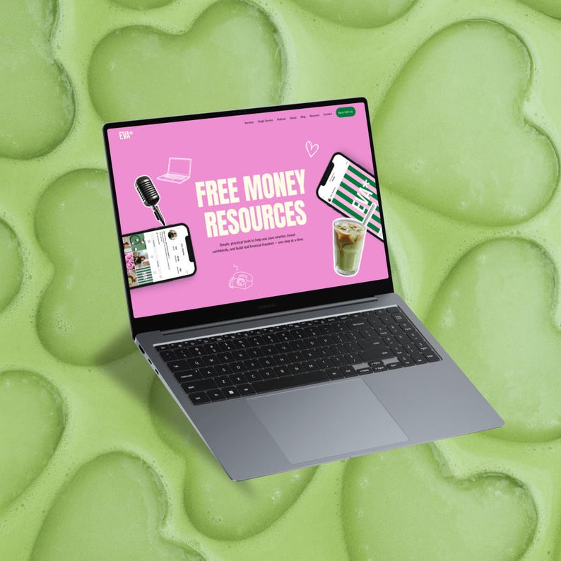 May include: A gray laptop displays a pink webpage with the text "FREE MONEY RESOURCES." The screen also shows a microphone, a smartphone, and a beverage. The laptop is set against a green, heart-shaped background.