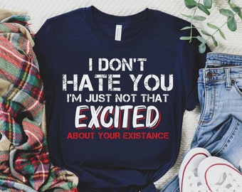 May include: A navy blue t-shirt with white text that reads "I don't hate you I'm just not that excited about your existence". The text is in a distressed font style.