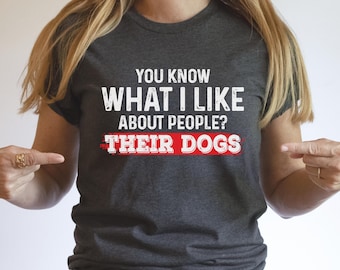 May include: A dark gray t-shirt with the text "You know what I like about people? Their dogs" in white with a red underline.