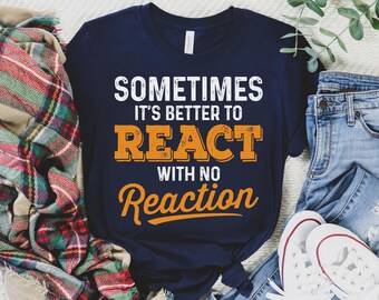 May include: A navy blue t-shirt with the text "Sometimes it's better to react with no reaction" in white and orange lettering.