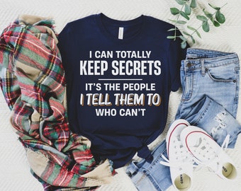 May include: A navy blue t-shirt with white text that reads "I can totally keep secrets. It's the people I tell them to who can't".