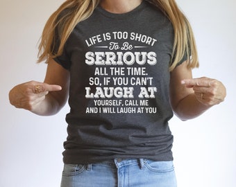 May include: A dark gray t-shirt with white text that reads "Life is too short to be serious all the time. So, if you can't laugh at yourself, call me and I will laugh at you."