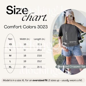 May include: A size chart for Comfort Colors 3023 oversized cropped tees. The chart shows measurements in inches for sizes XS to XL. The model in the image is wearing an XL for an oversized fit. The tee is dark gray.