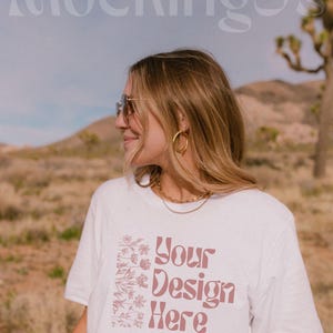 May include: A white t-shirt with a pink floral design and the text 'Your Design Here'.