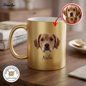 May include: A gold-colored mug featuring a portrait of a Golden Retriever dog named Nala. The mug has a gold handle and a white interior. The mug is on a wooden surface. The mug is labeled "Designed by Real Artists, Authentic Creation."
