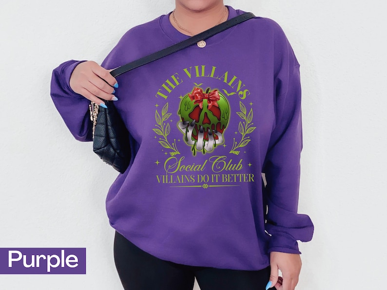 May include: A purple sweatshirt with a graphic design featuring a green skull with a red bow, surrounded by a laurel wreath. The text reads "The Villains Social Club, Villains Do It Better."