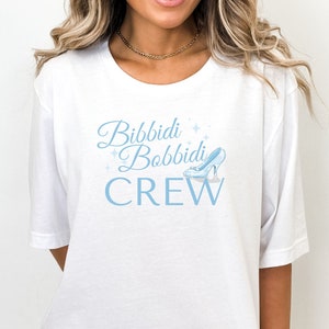 May include: White t-shirt with a blue graphic that says "Bibbidi Bobbidi Crew" with a glass slipper graphic.